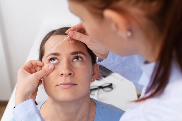 Doctor testing patient eyesight during routine eye exam in clinic.